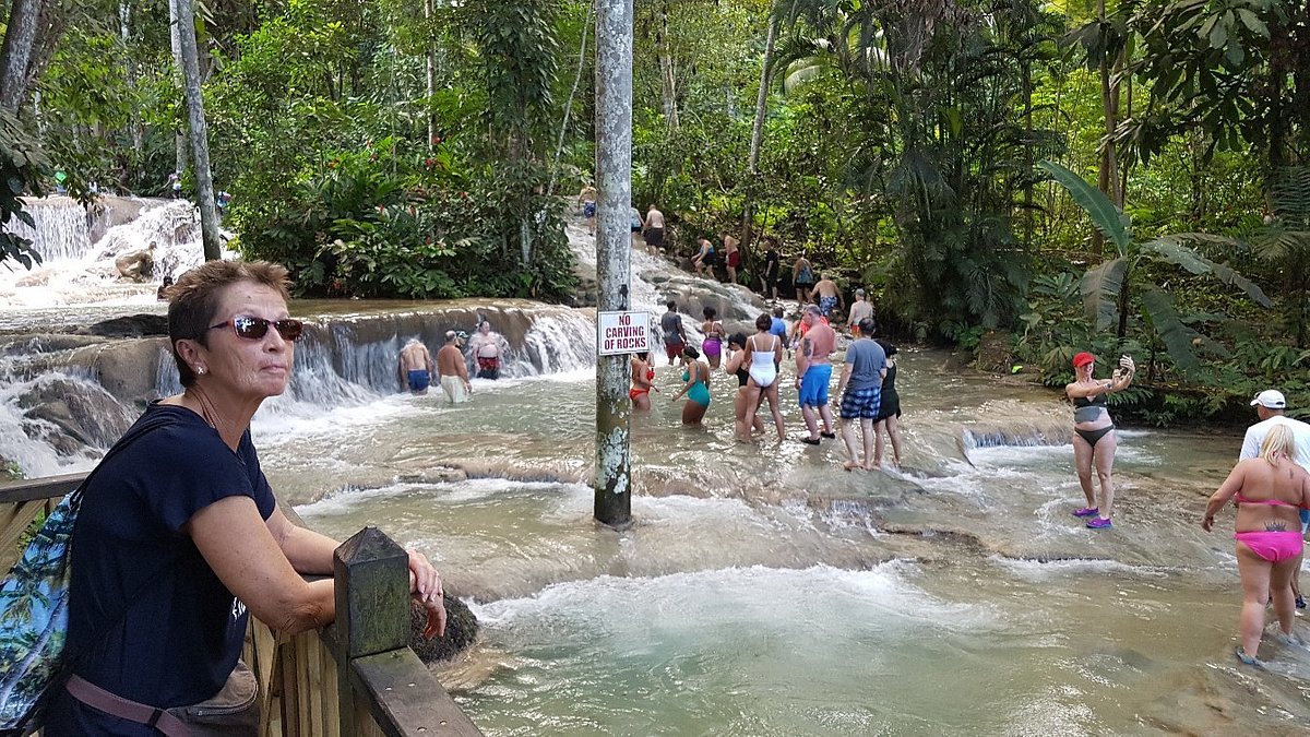 Tourist  admiring Dunn's River Falls, enjoying the scenic beauty without climbing.