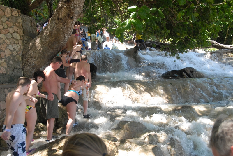 Climbers tackling Dunn's River Falls in lush Jamaican landscape