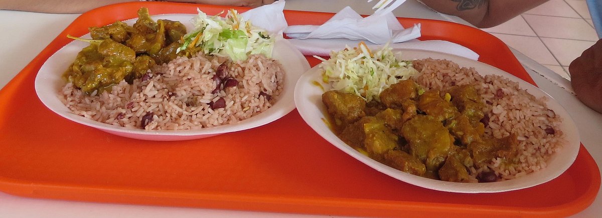 Traditional Jamaican plates with curried goat and sides