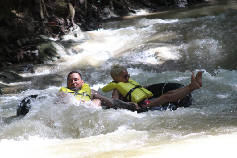 Visitors floating down White River amid Jamaica's tropical landscape