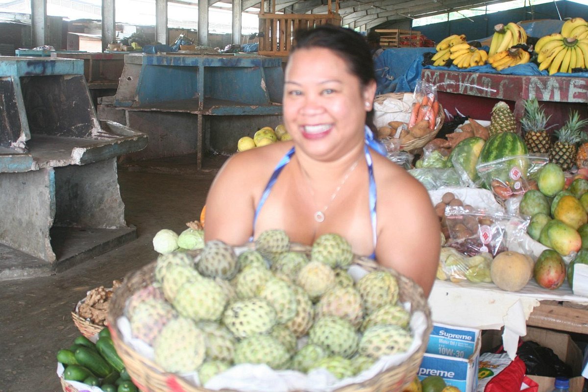 Tourist holding a basket of fresh local fruit in Montego Bay market