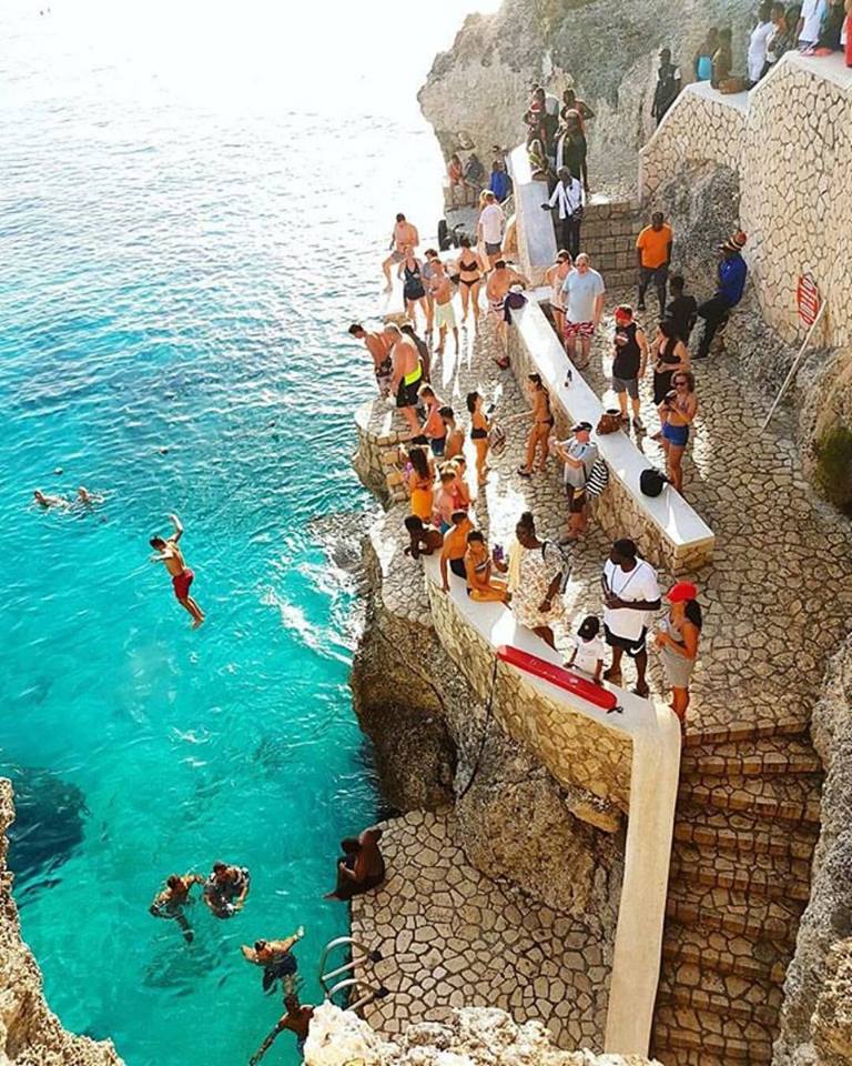 Adventurous person cliff diving into clear waters at Rick’s Café