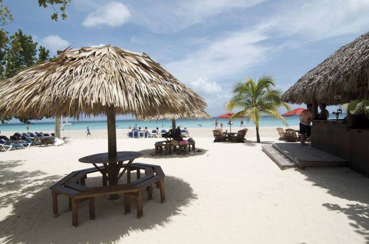 Guests relaxing under a gazebo on Seven Mile Beach, Jamaica.