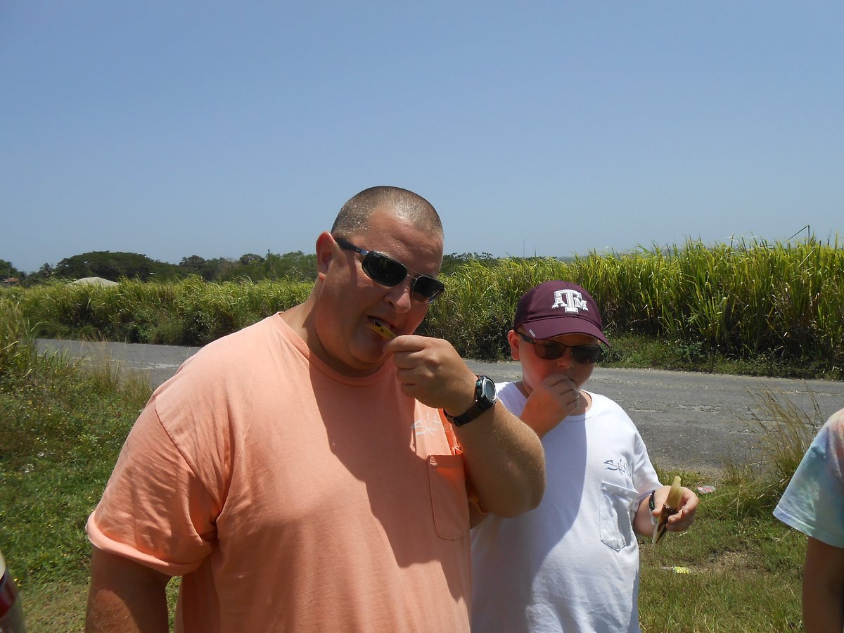 Visitors relishing pure sugar cane at a Jamaican market