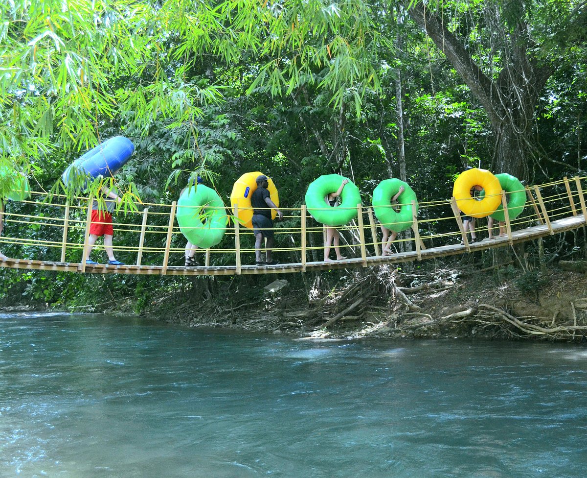 Tubers crossing a wooden jungle bridge over Rio Bueno in Jamaica