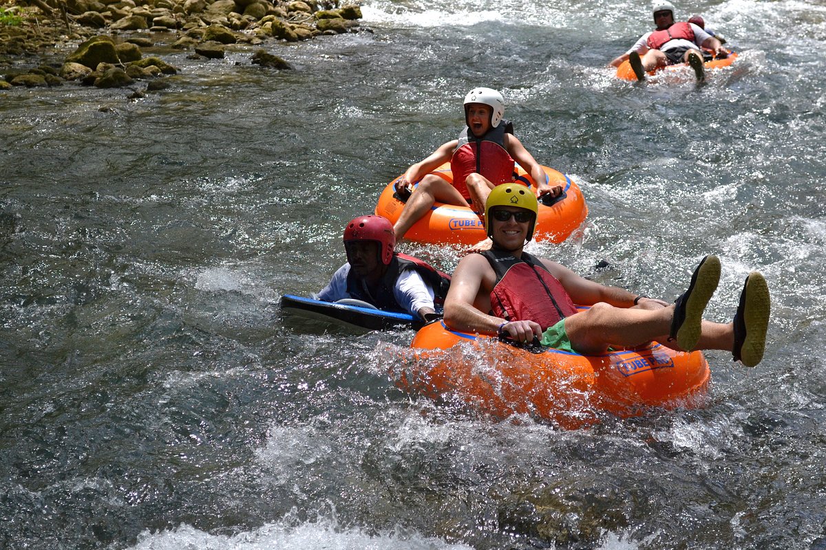 Tourists enjoying a calm section of the Rio Bueno river under a canopy of jungle