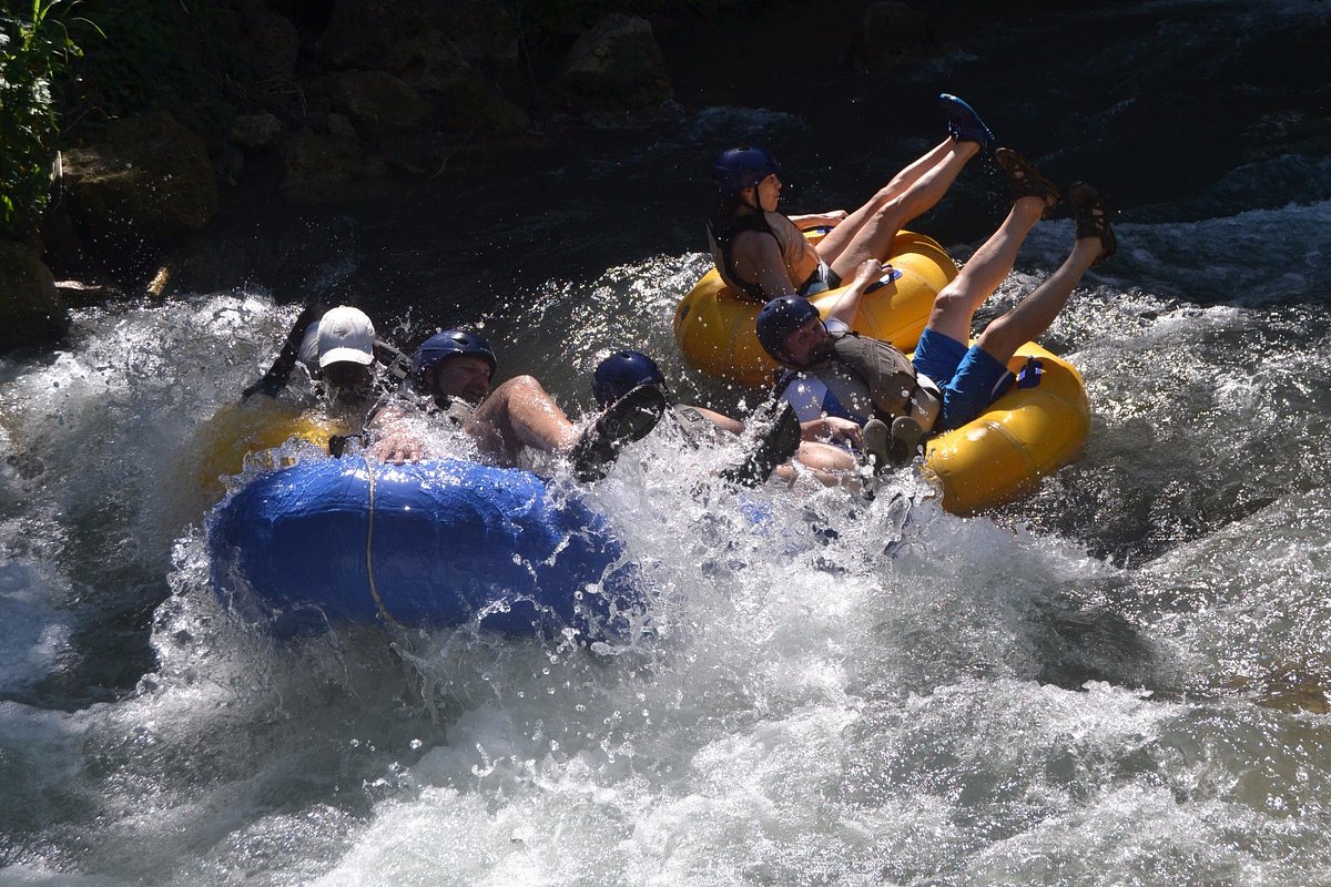 Image of a group of adventurers enjoying river tubing through exciting rapids