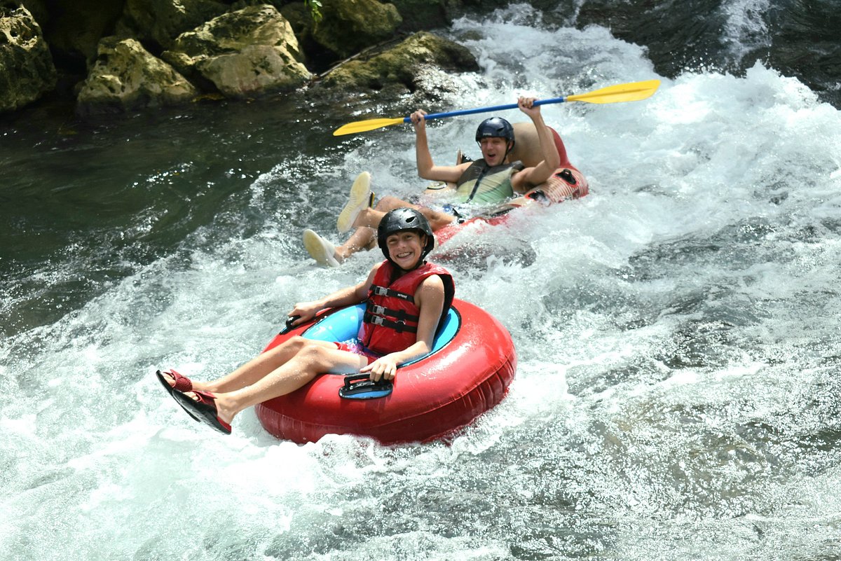 Adventurers navigating rapids on a jungle river tubing experience