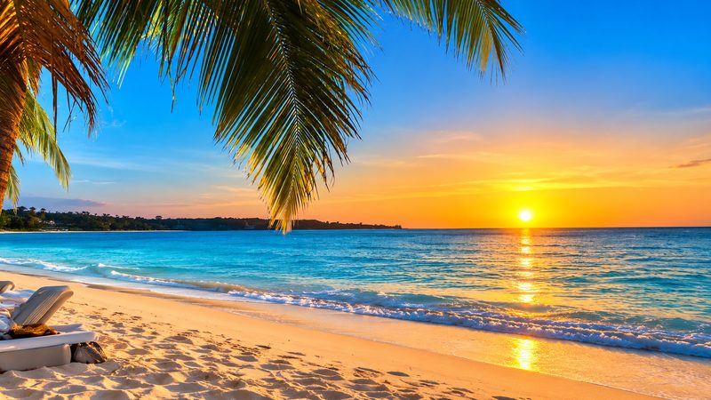 Negril Jamaica sunset over the Caribbean Sea with a tropical beach and coastal cliffs